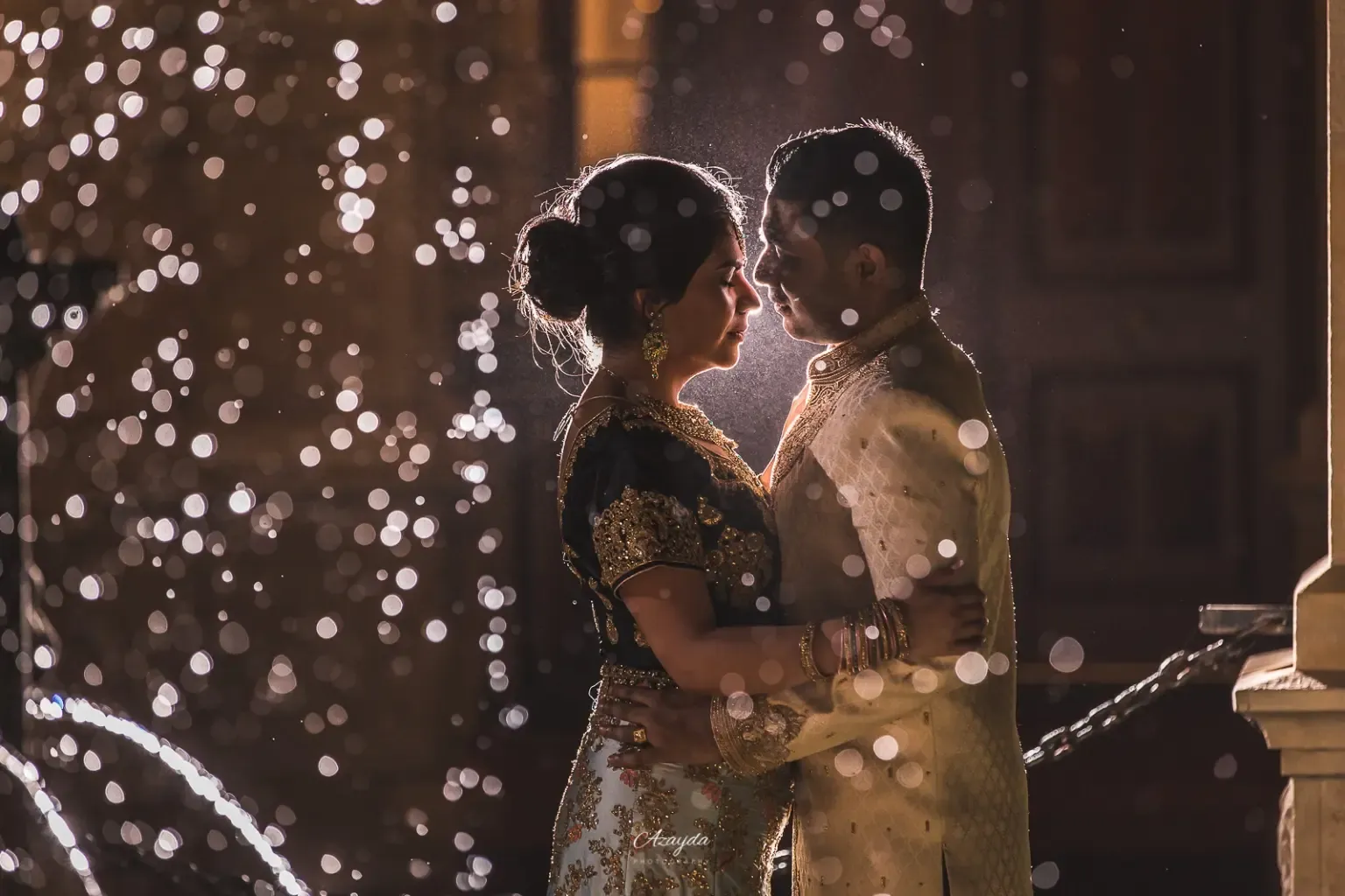 Wedding portrait beneath falling lights at an evening celebration