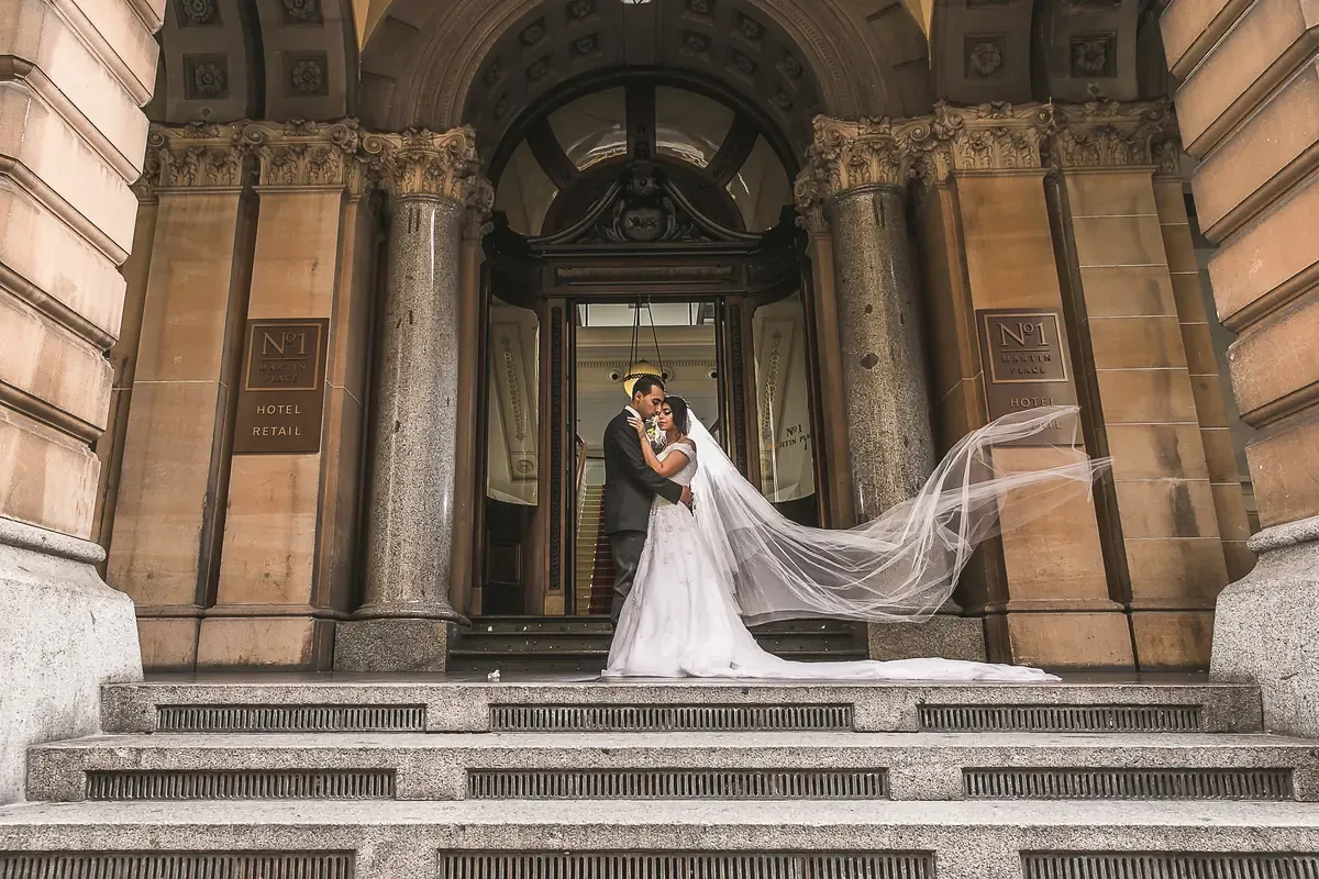 A couple embracing at the No. 1 Martin Place entrance in Sydney CBD with a veil extending across the steps