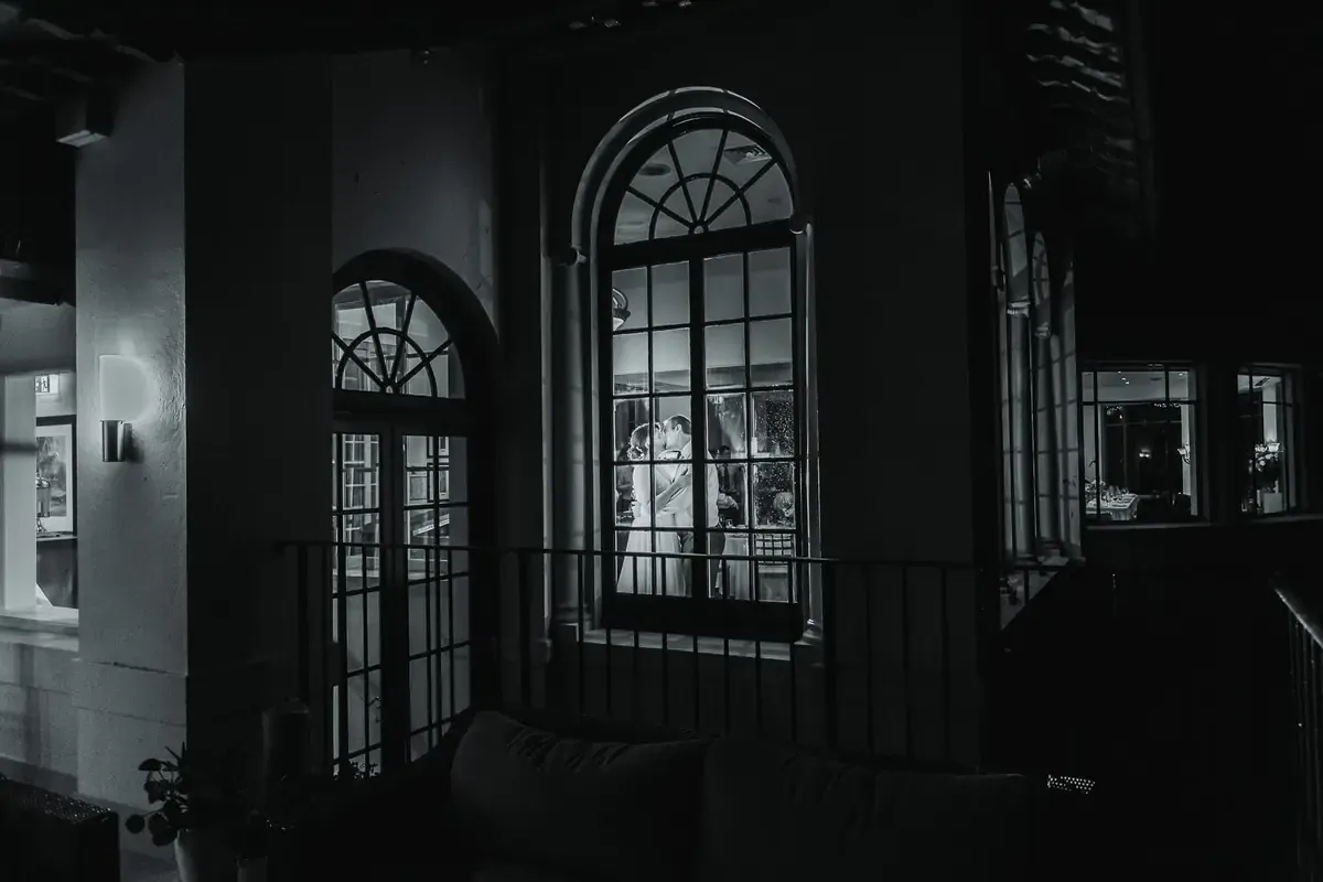 A couple kissing through arched windows at Manly Golf Club in Sydney’s Northern Beaches