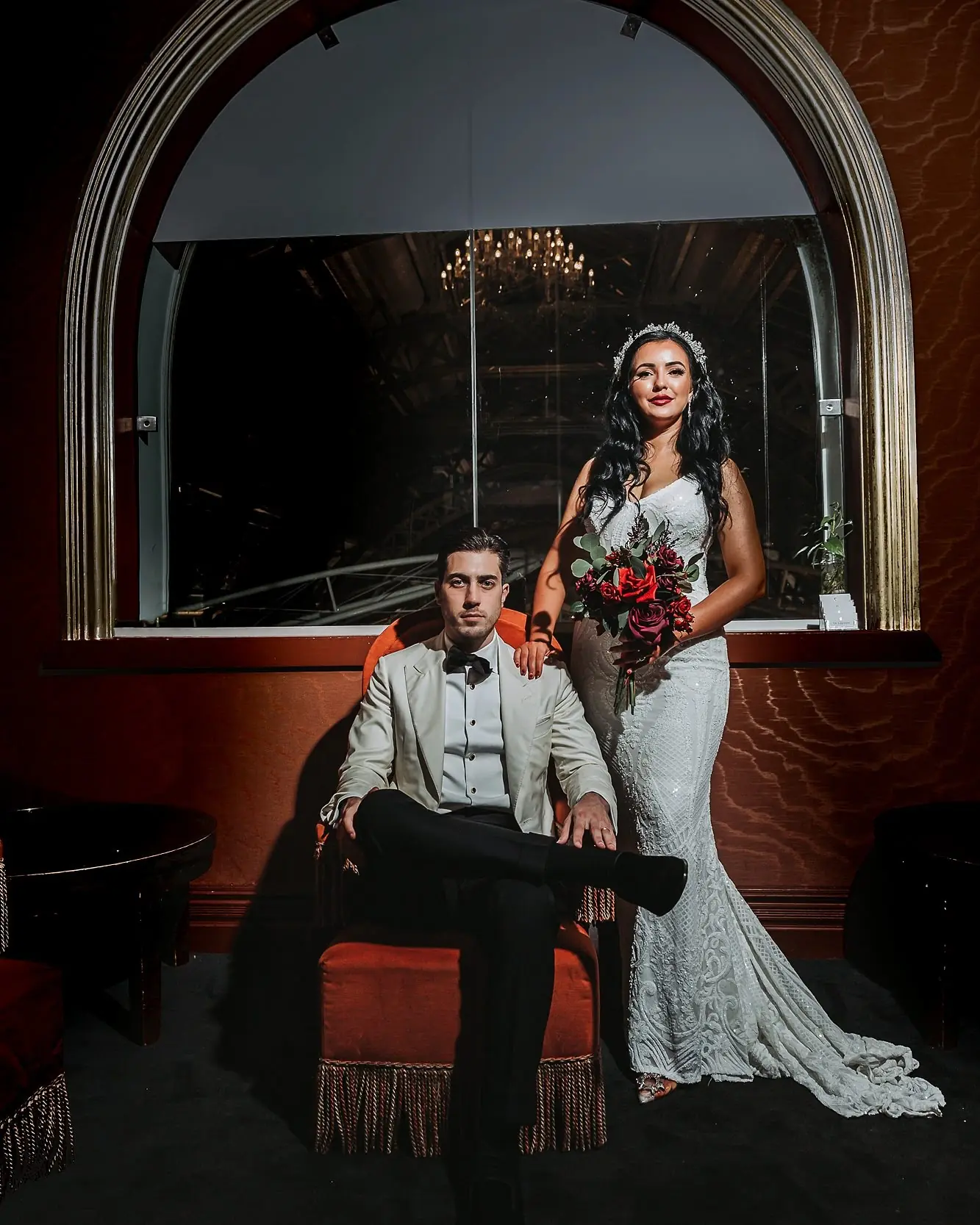 Couple together beneath an arched mirror in a reception room