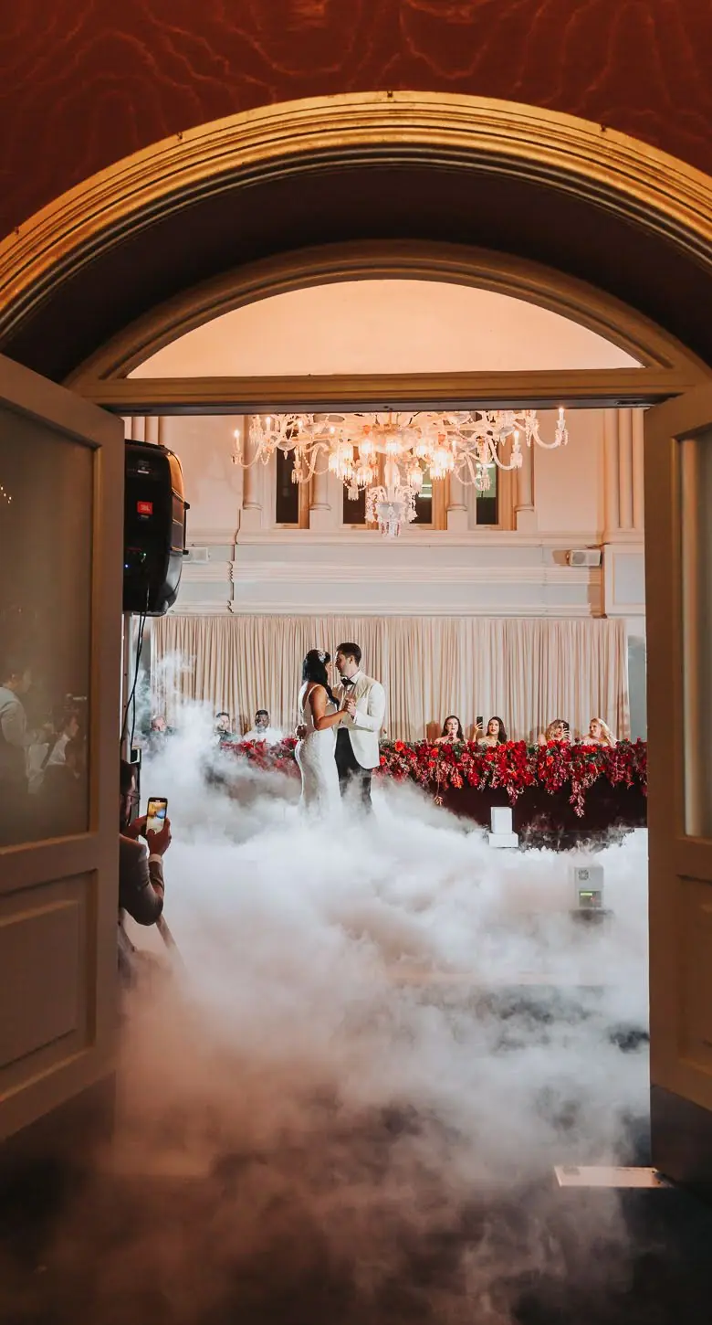 A couple dancing in The Tea Room, QVB beneath a chandelier, red florals and fog