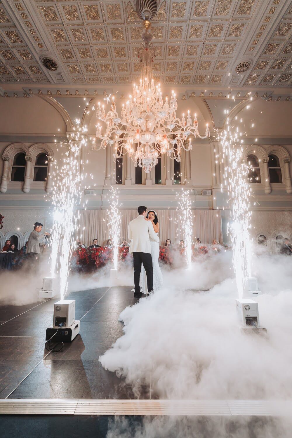 Ivana and Ivan dancing beneath The Tea Room chandelier as indoor sparklers rise around them